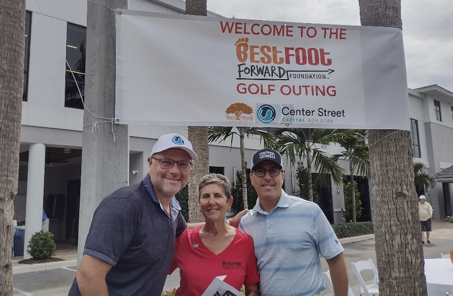 staff in front of sign that says -- welcome to the best foot forward foundation